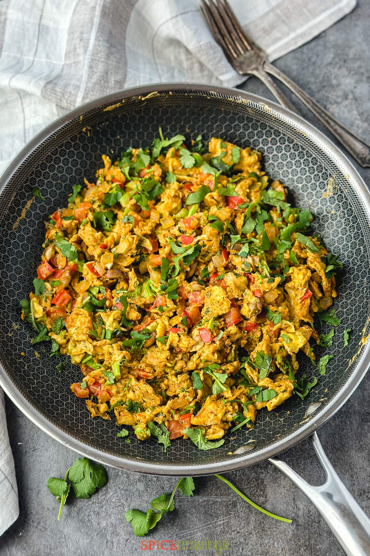 Egg bhurji in a black skillet.