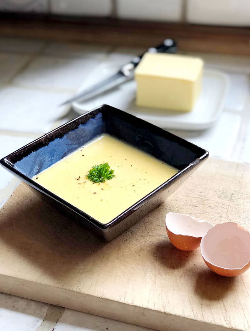 Hollandaise sauce in a square bowl.