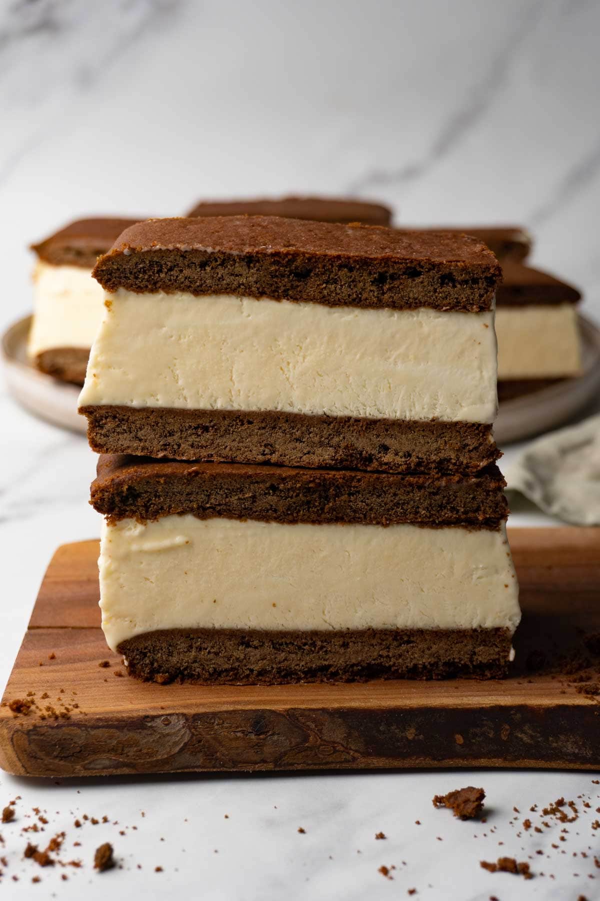 Close up of a stack of homemade ice cream sandwiches on a wooden board.
