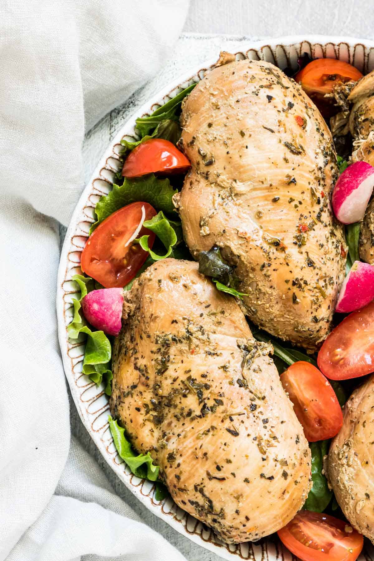 Instant pot frozen chicken breast with vegetables on a platter.