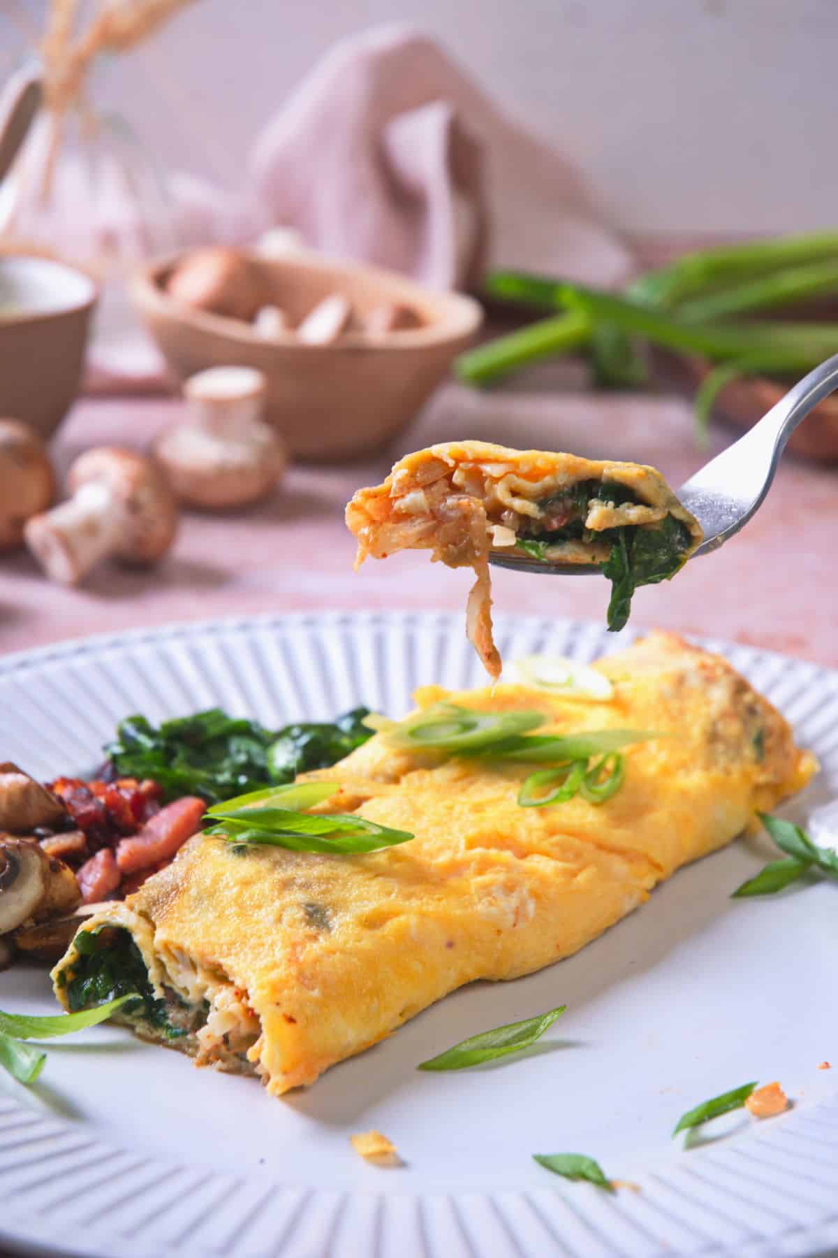 Forkful of kimchi omelet with more on a plate.
