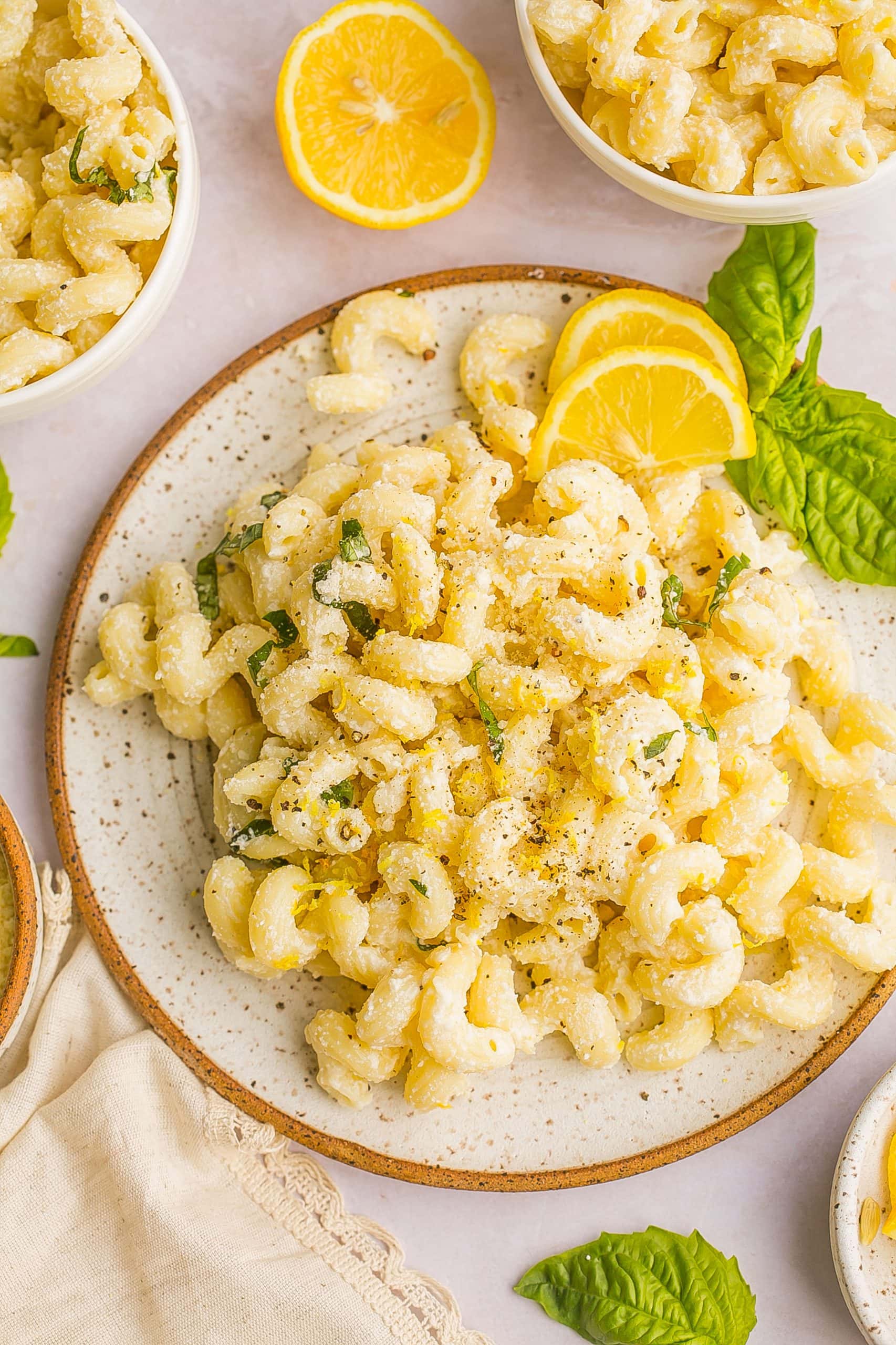 Lemon and ricotta pasta on a speckled plate.