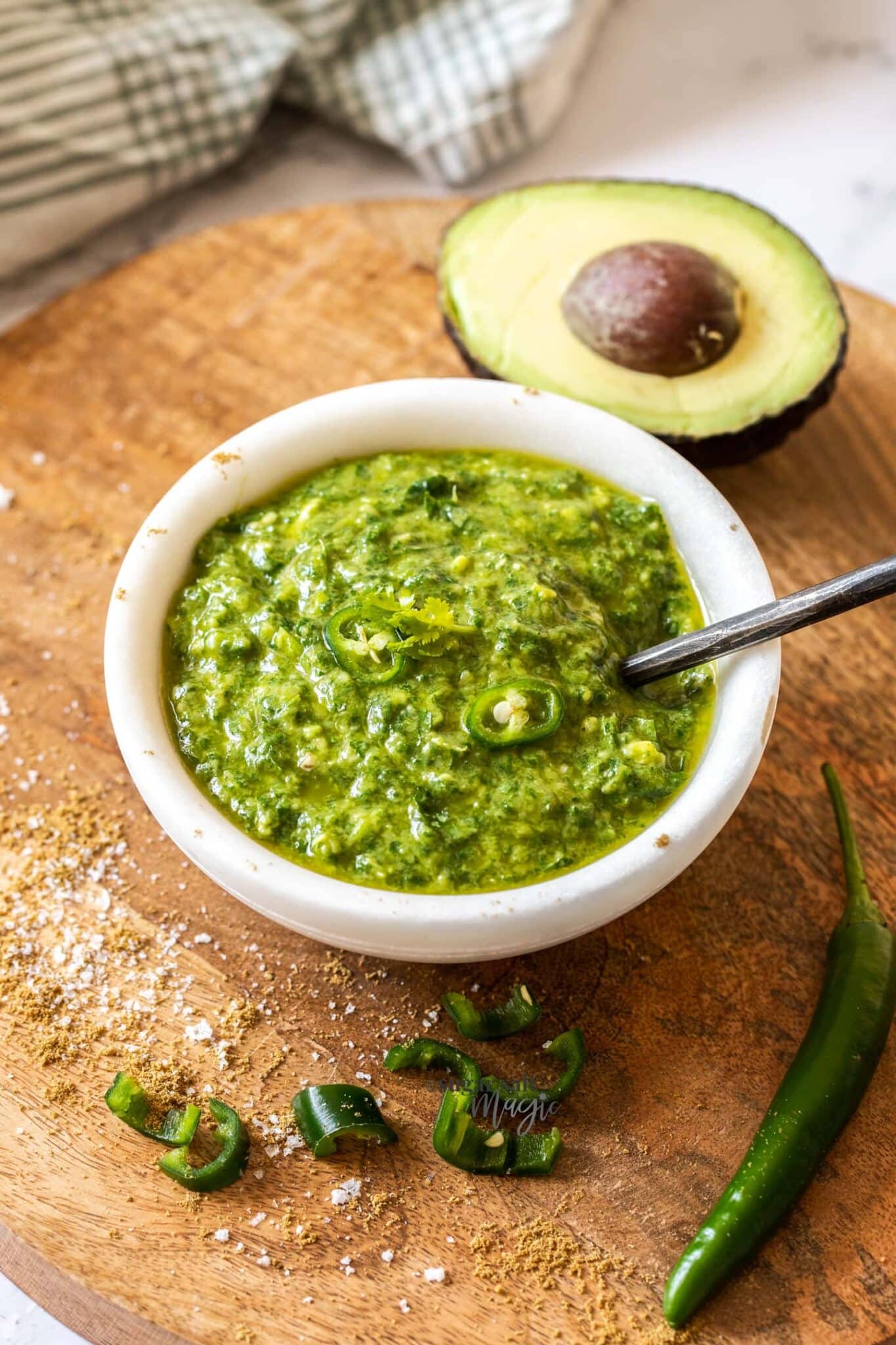 Spanish green sauce in a white bowl on a wooden surface.