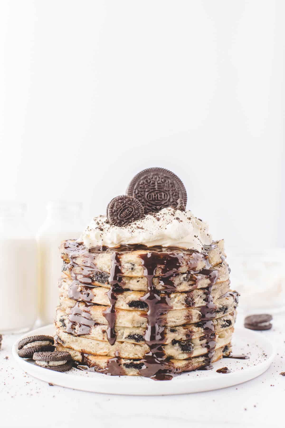 Stack of Oreo pancakes dripping chocolate sauce.