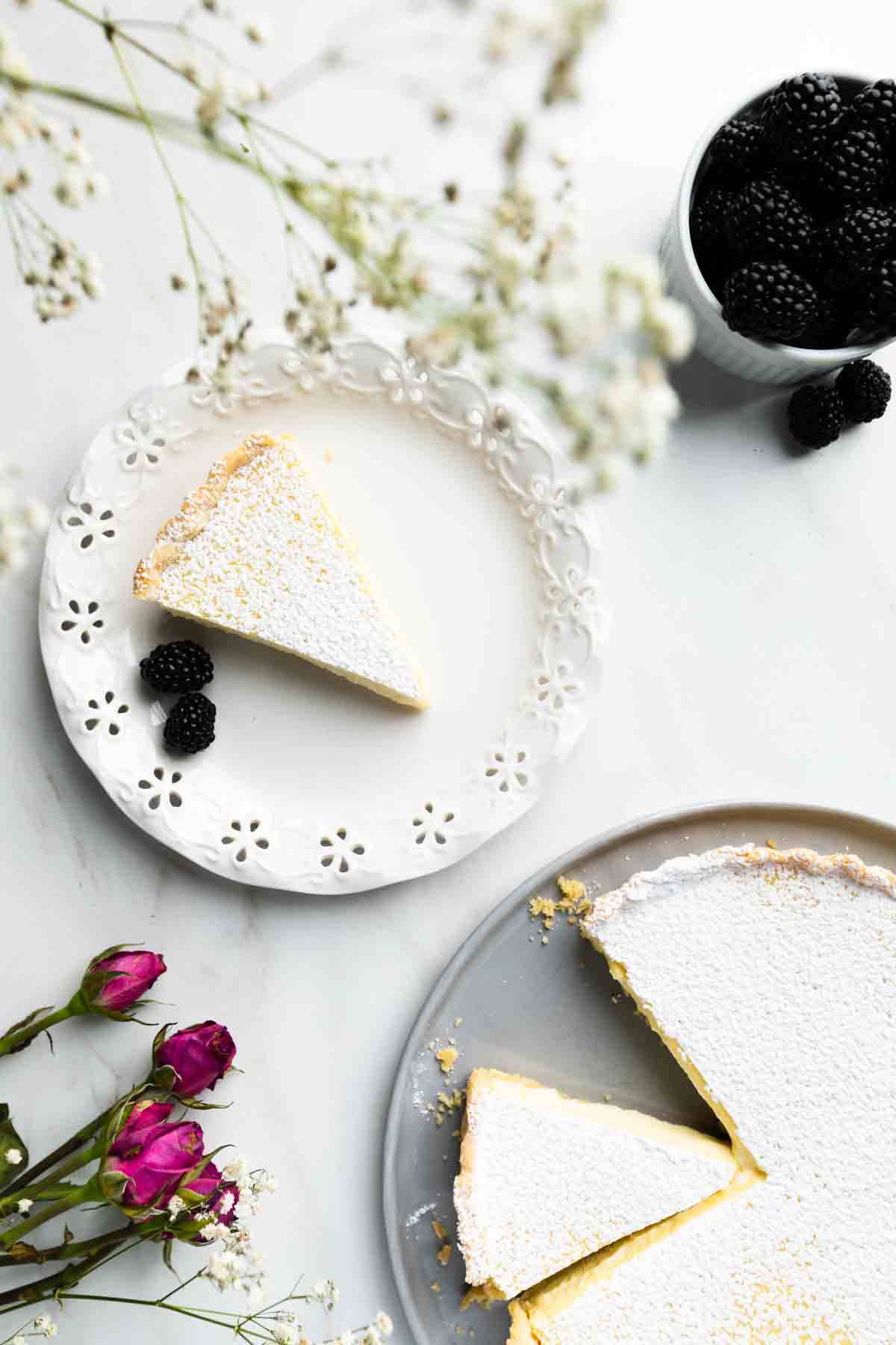 Slice of ricotta pie with rest of pie in the background.