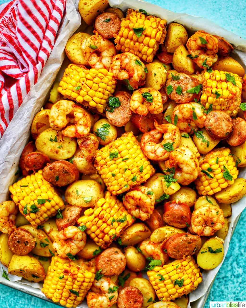 Low country boil with corn, sausage, potatoes, and shrimp on a sheet pan.