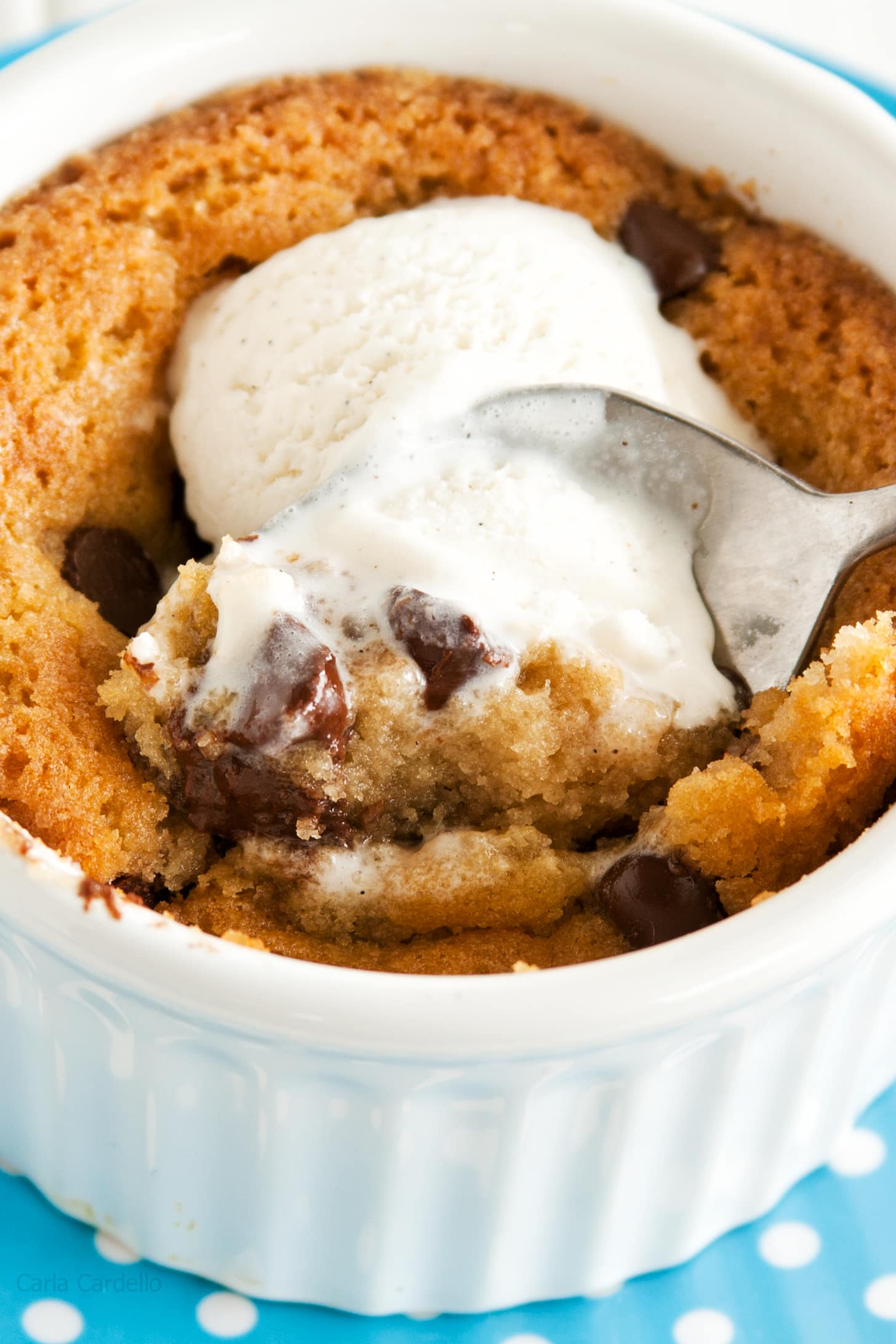 Single serving of chocolate chip cookie in a white ramekin with spoon.