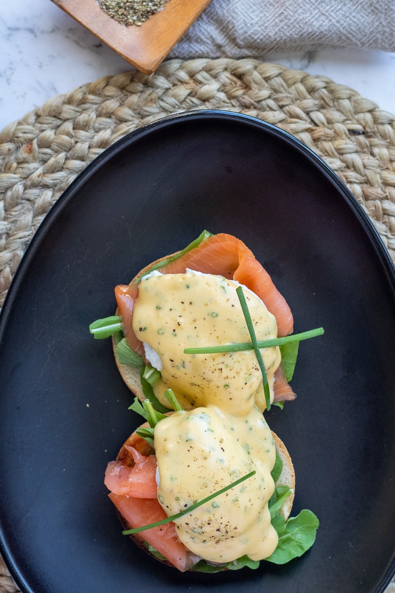 Smoked salmon eggs benedict on black plates.