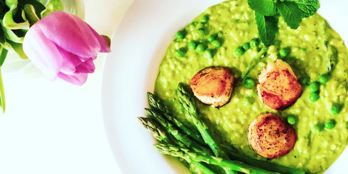 Green pea risotto in a white bowl.