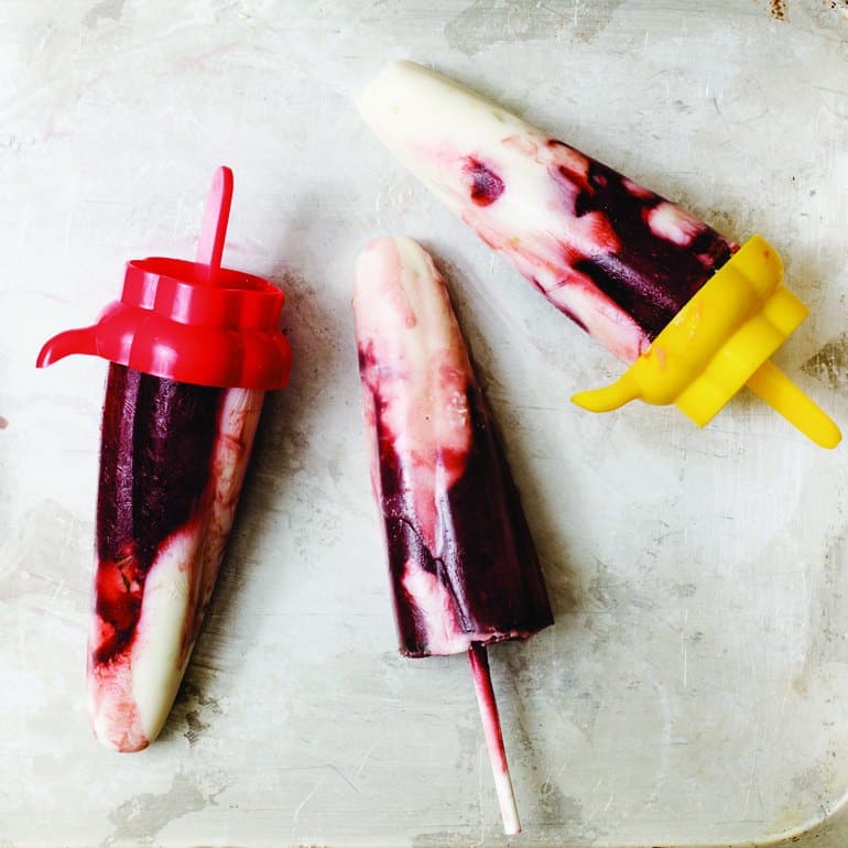 Purple and white popsicles with colorful holders.