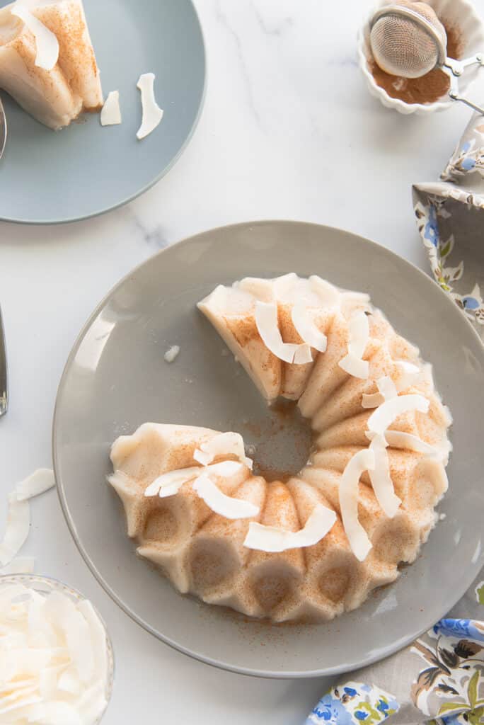 Puerto Rican coconut pudding on a plate with a slice removed.