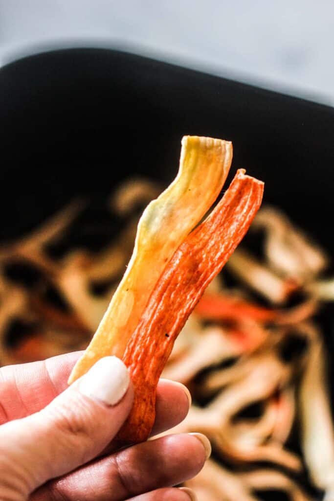 Hand holding air fryer crab sticks.