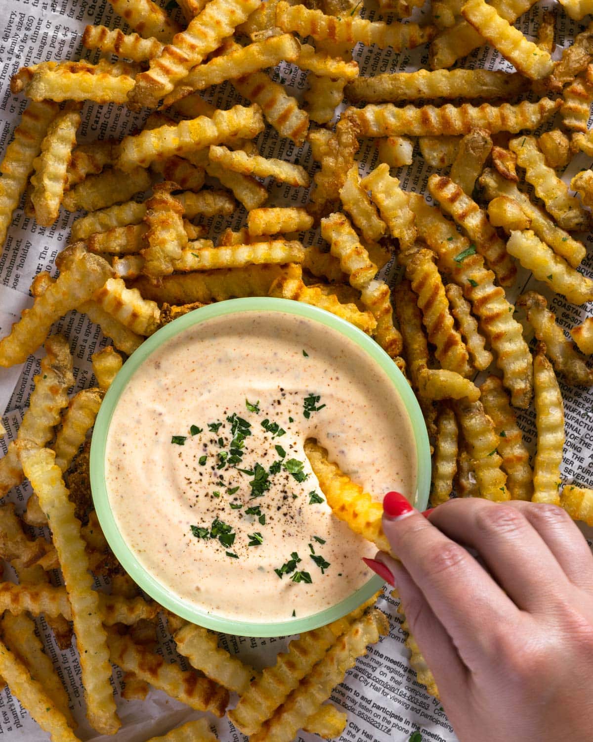 Hand dipping fry in spicy Cajun garlic aioli.