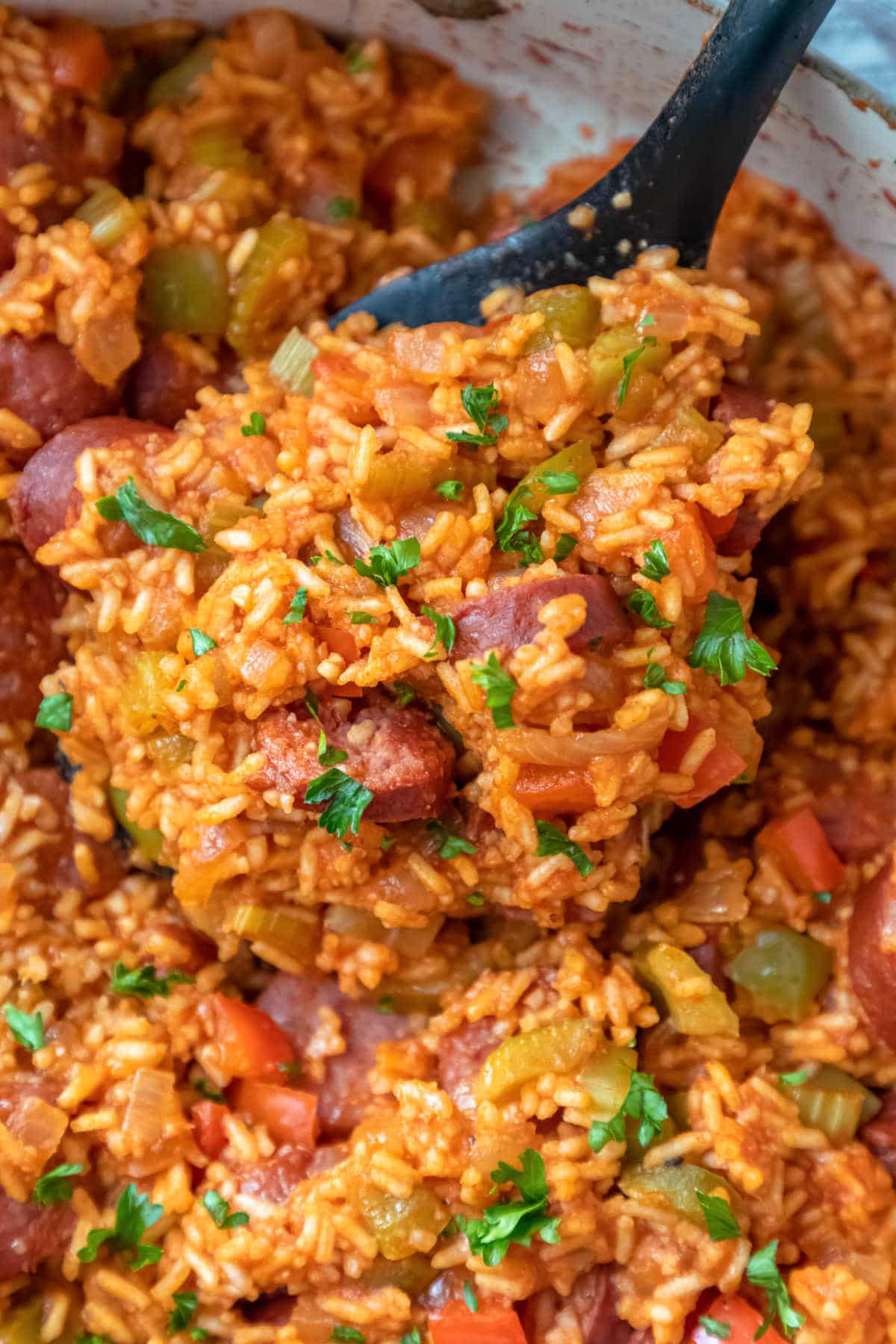 Cajun sausage and rice with spoon in a pot.