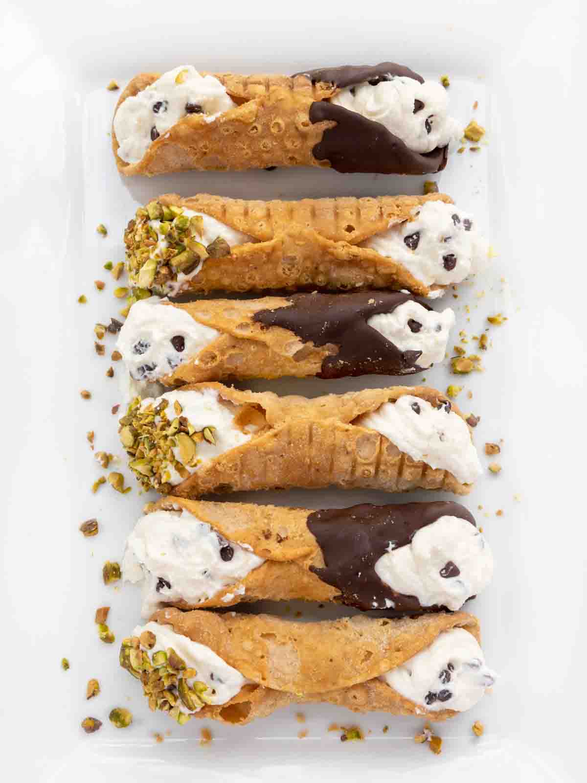 Cannolis on a white square plate.
