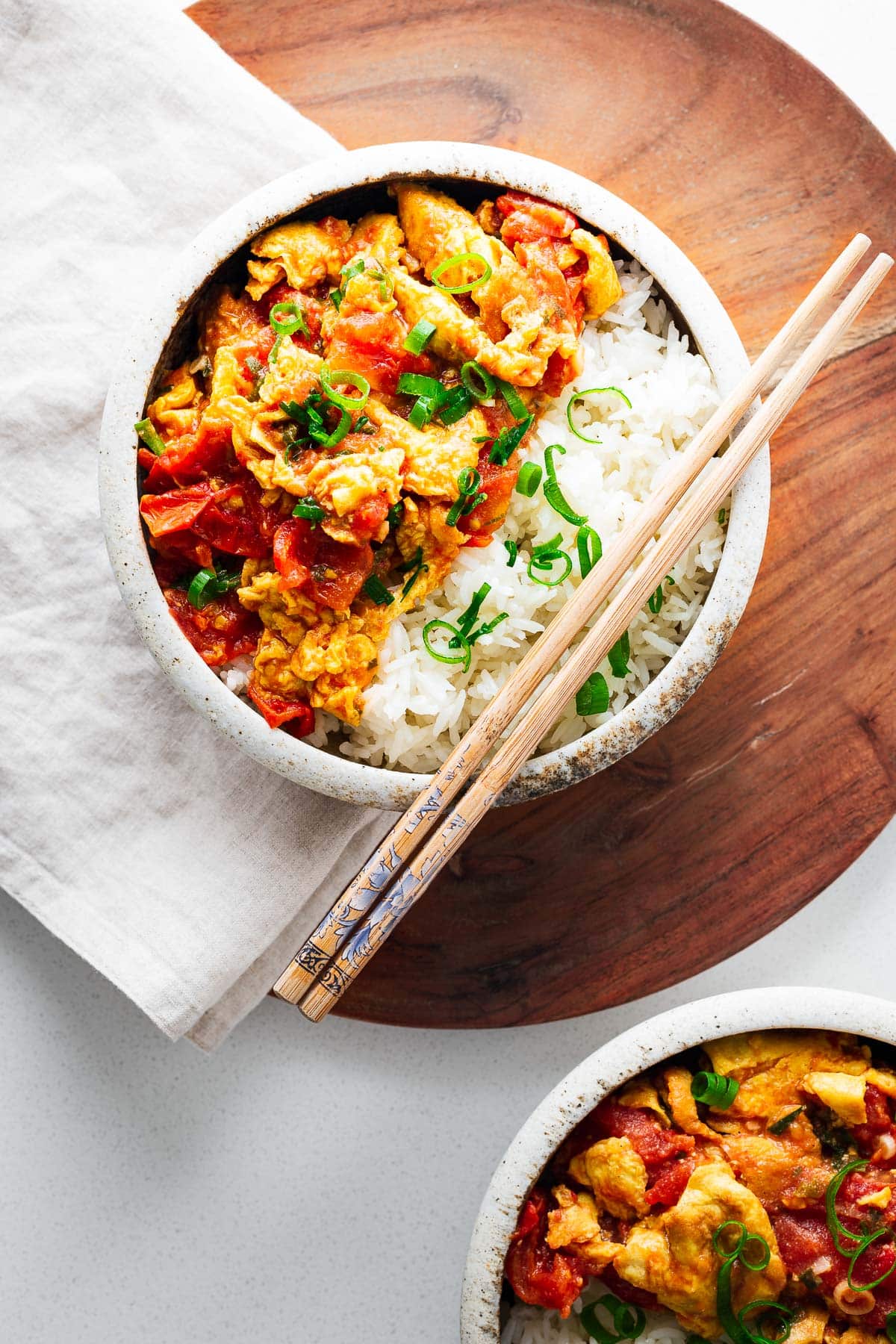 Chinese egg stir fry with rice and chopsticks in a bowl.