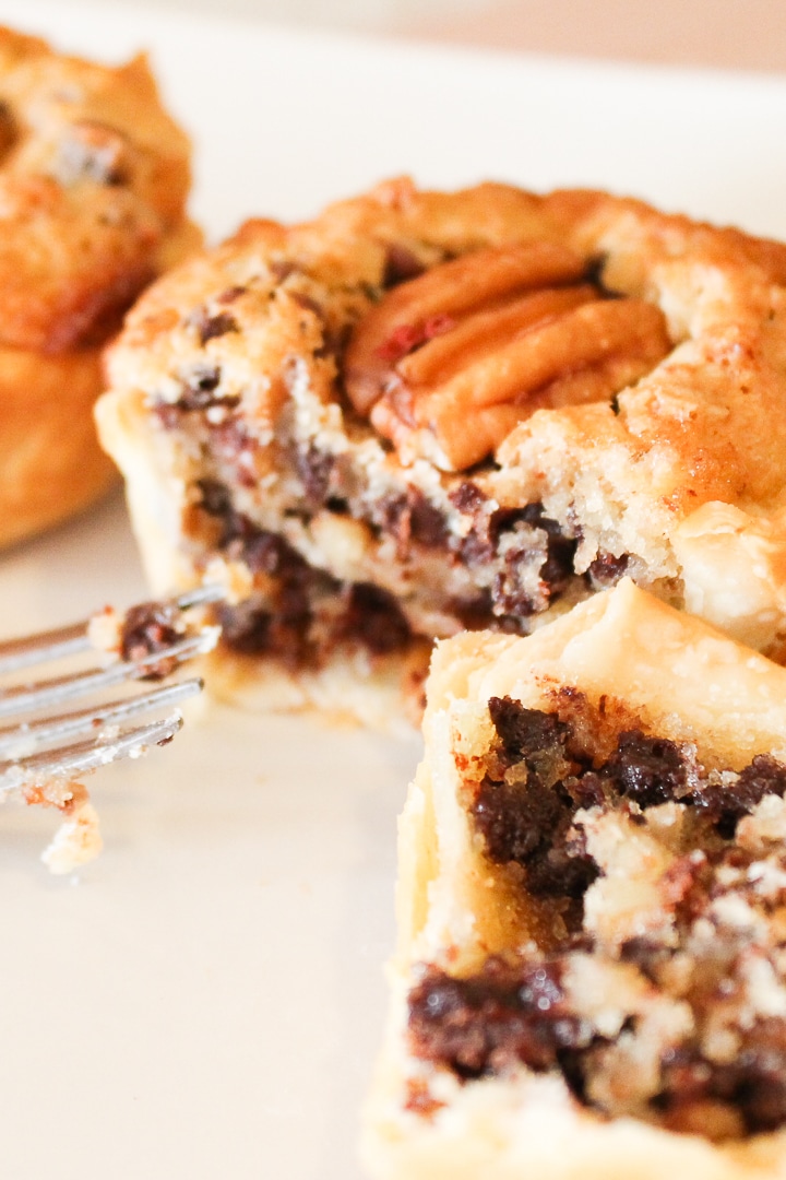 Mini chocolate pecan pie on white plate.