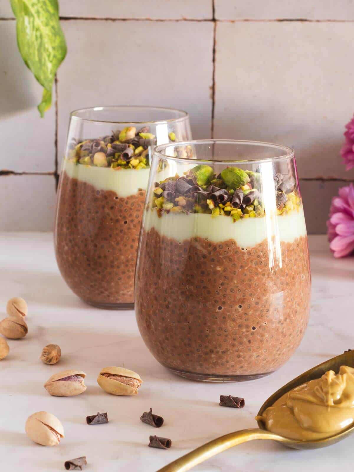 Chocolate chia pudding cups with flowers in the background.