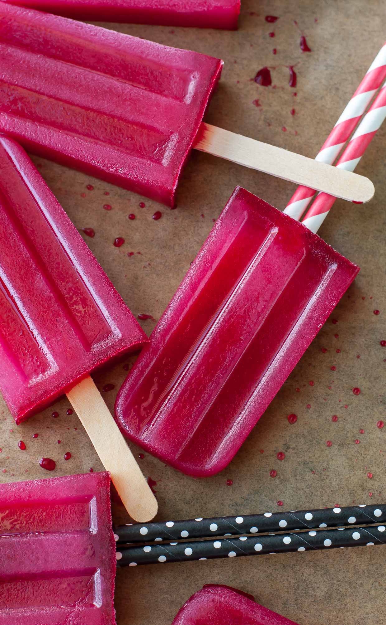 Fuchsia colored green tea hibiscus popsicles on parchment. 