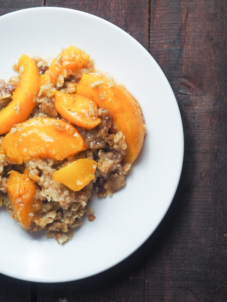 Spiced peach crisp on a small white plate.