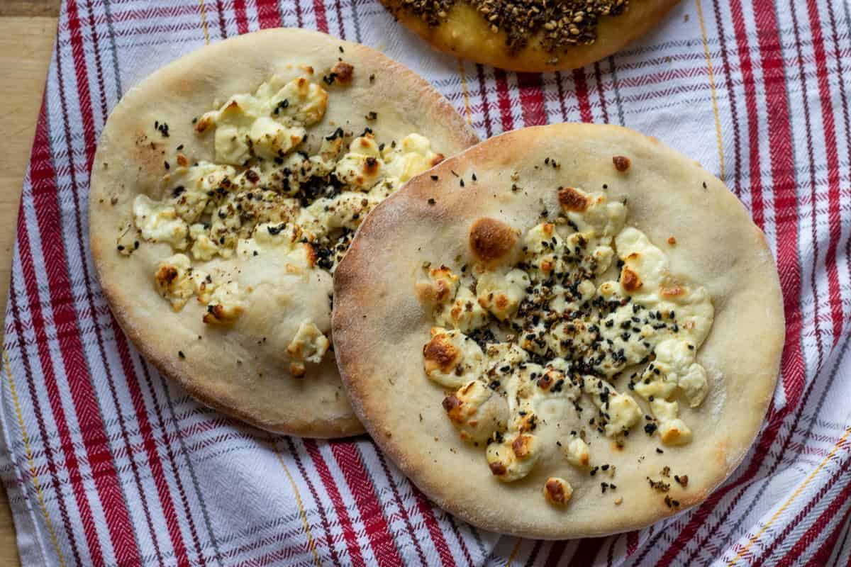 Manakish with za'atar and cheese on a dish towel.