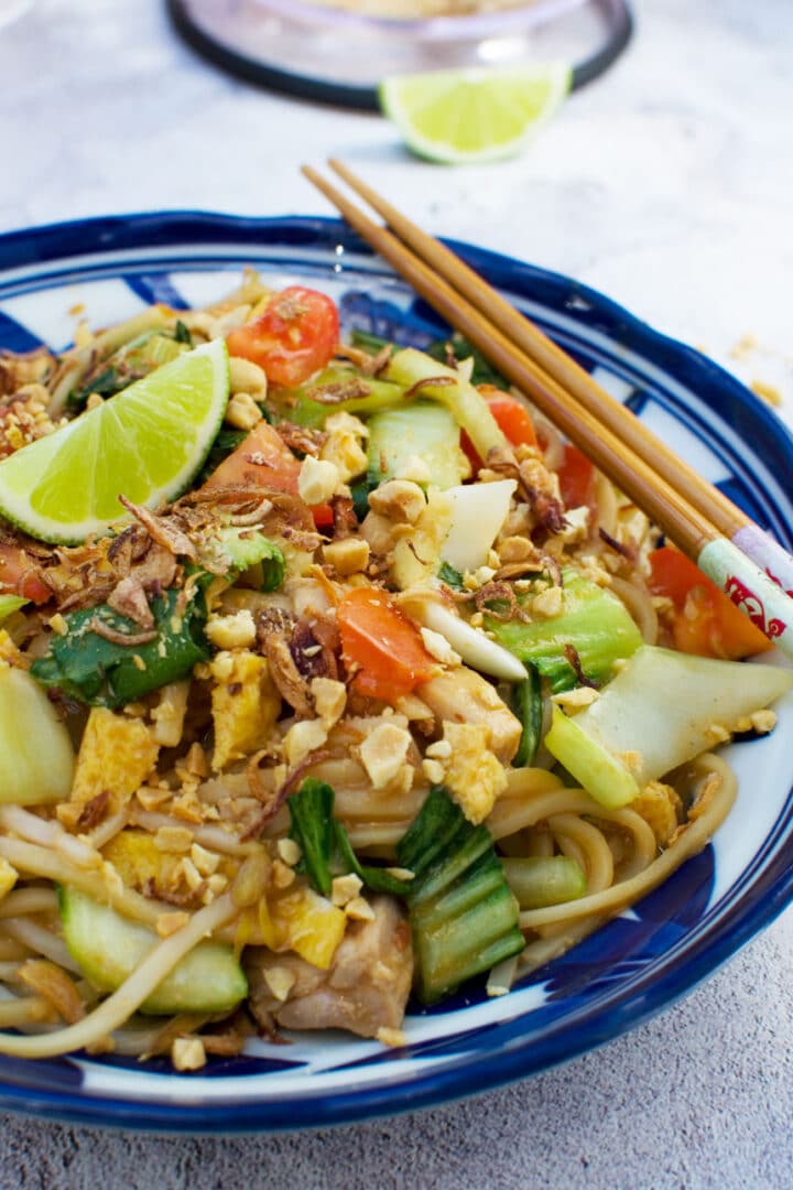 Noodle stir fry on a blue plate.