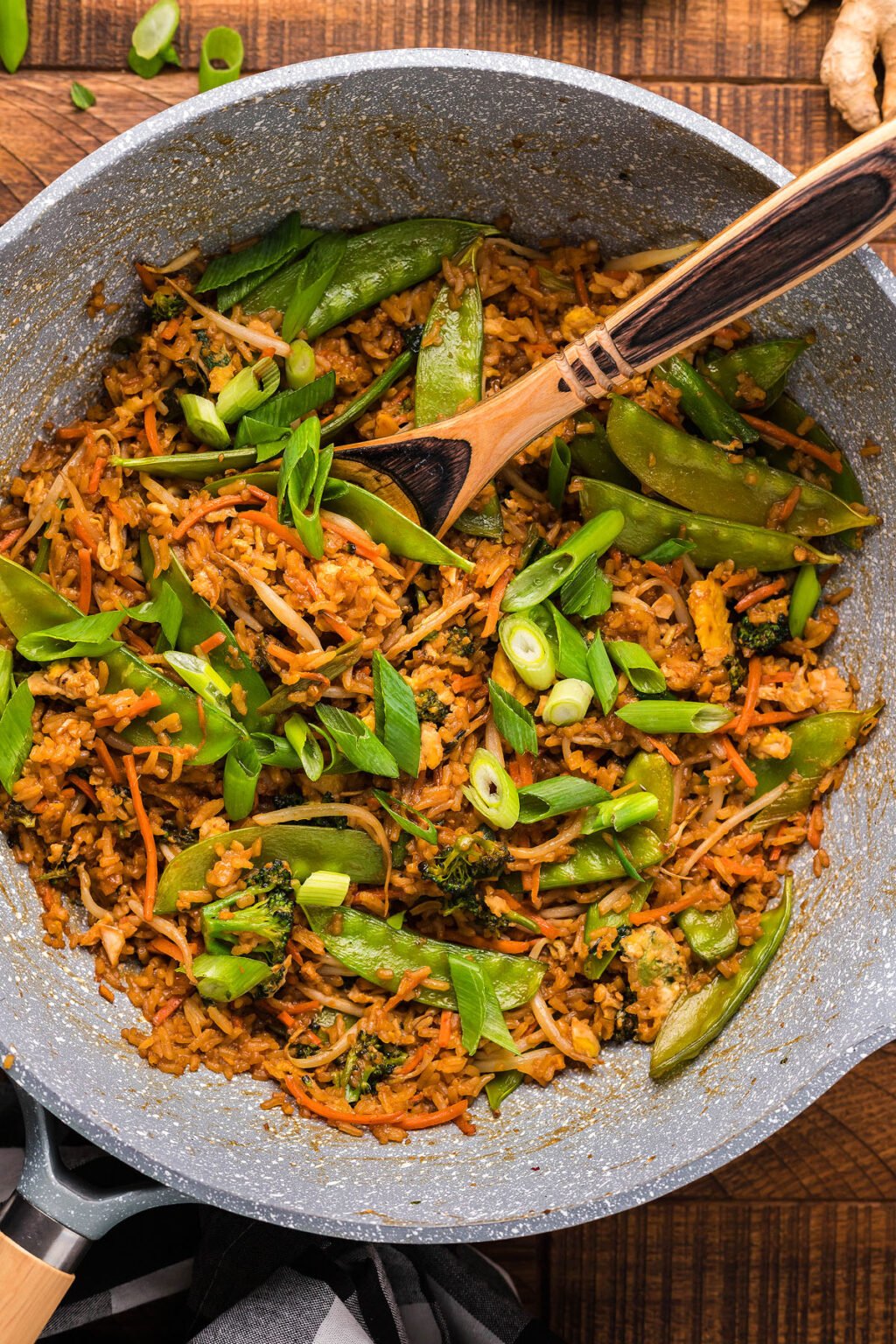 Fried rice in a large grey bowl with large wooden spoon.