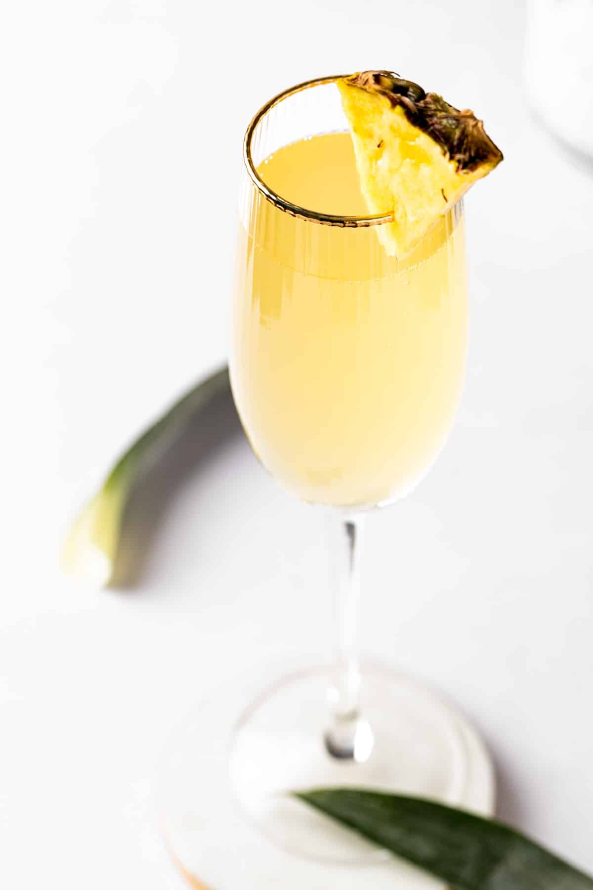 Pineapple mimosa in a champagne glass.