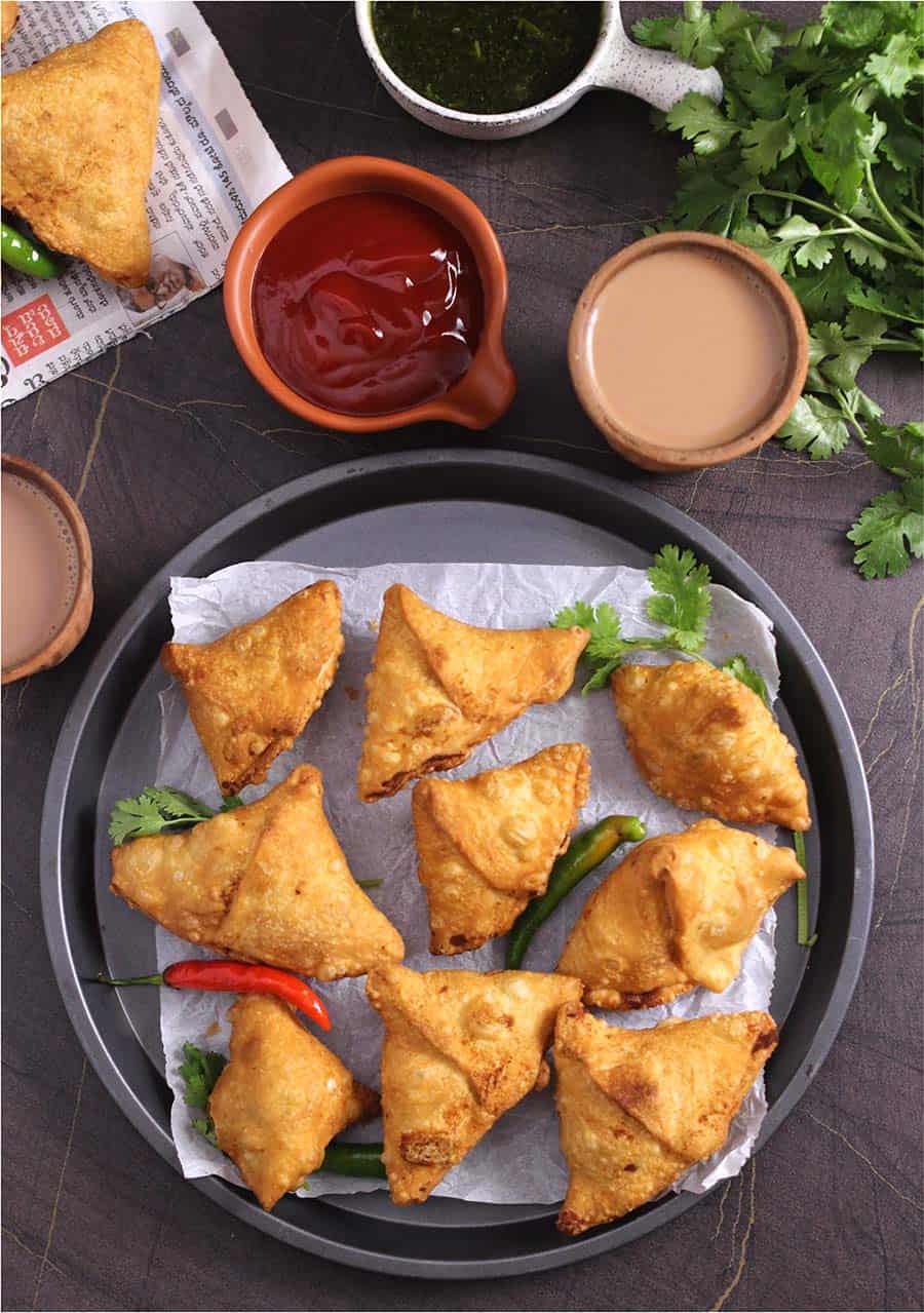 Samosas on a parchment lined plate.