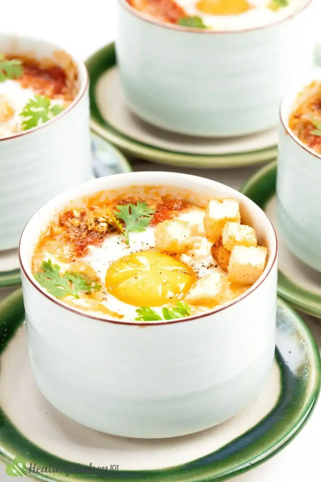 Egg in baking dish with croutons and herbs.