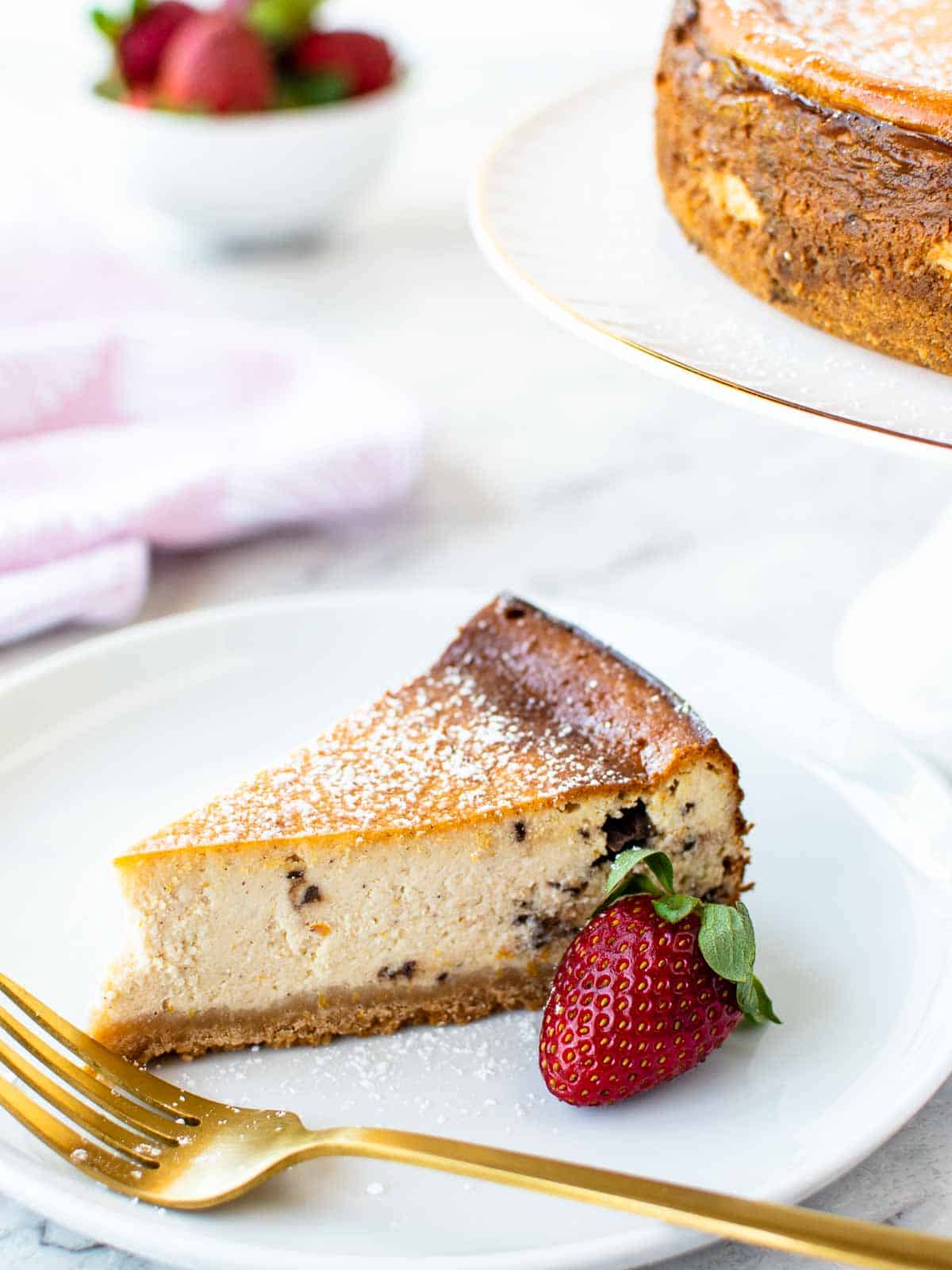 Slice of ricotta crumble cheesecake on a plate with golden colored fork.