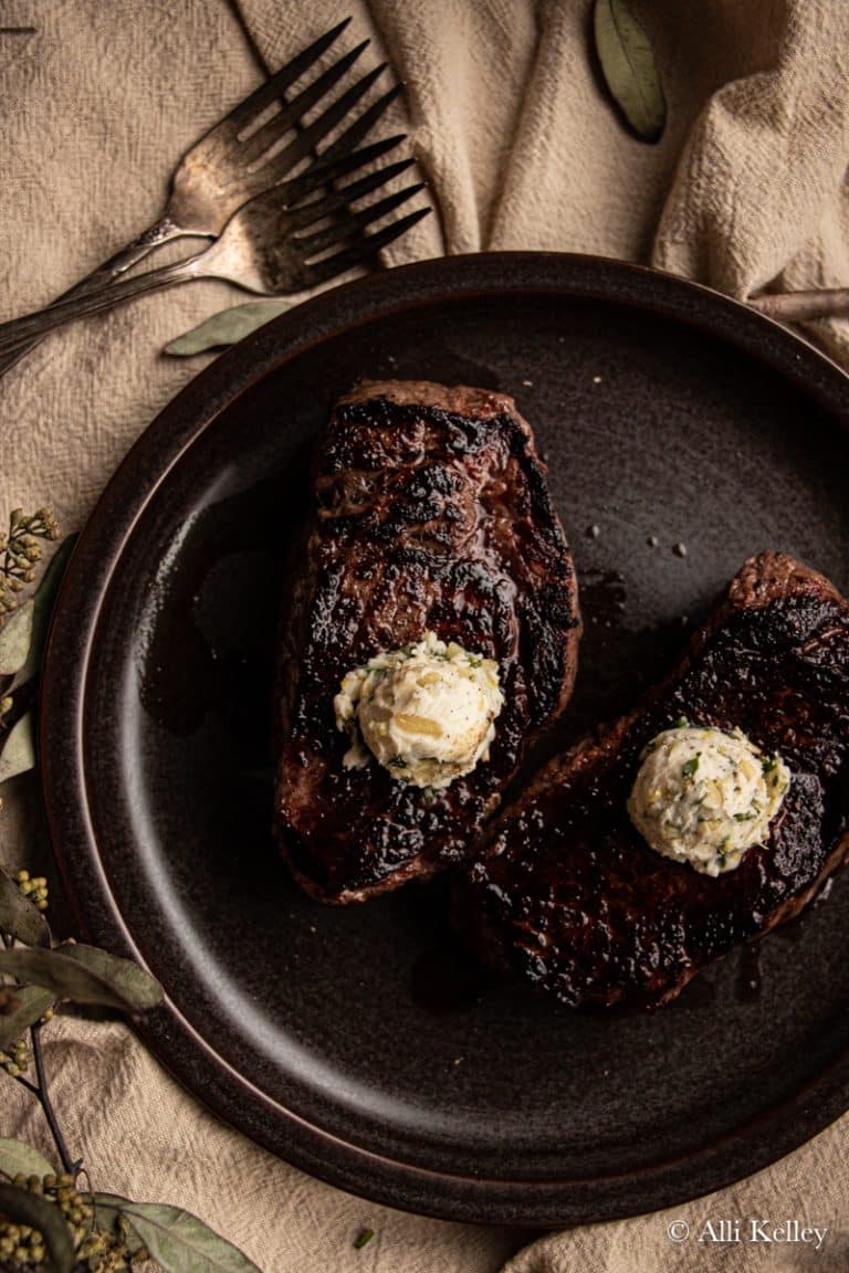 Steak herb butter on a dark plate.