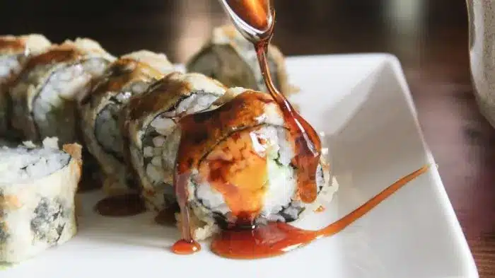 Tempura fried sushi, sliced, on a plate.