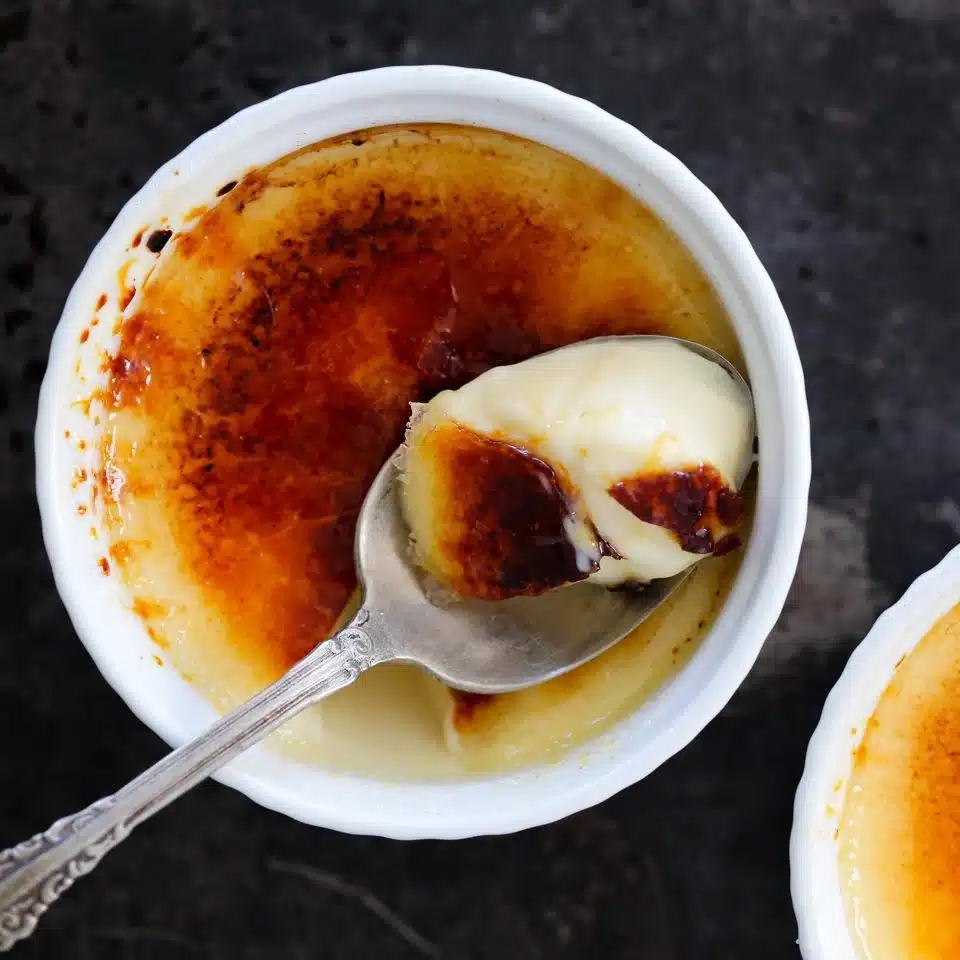 Vanilla bean creme brulee in white ramekins.