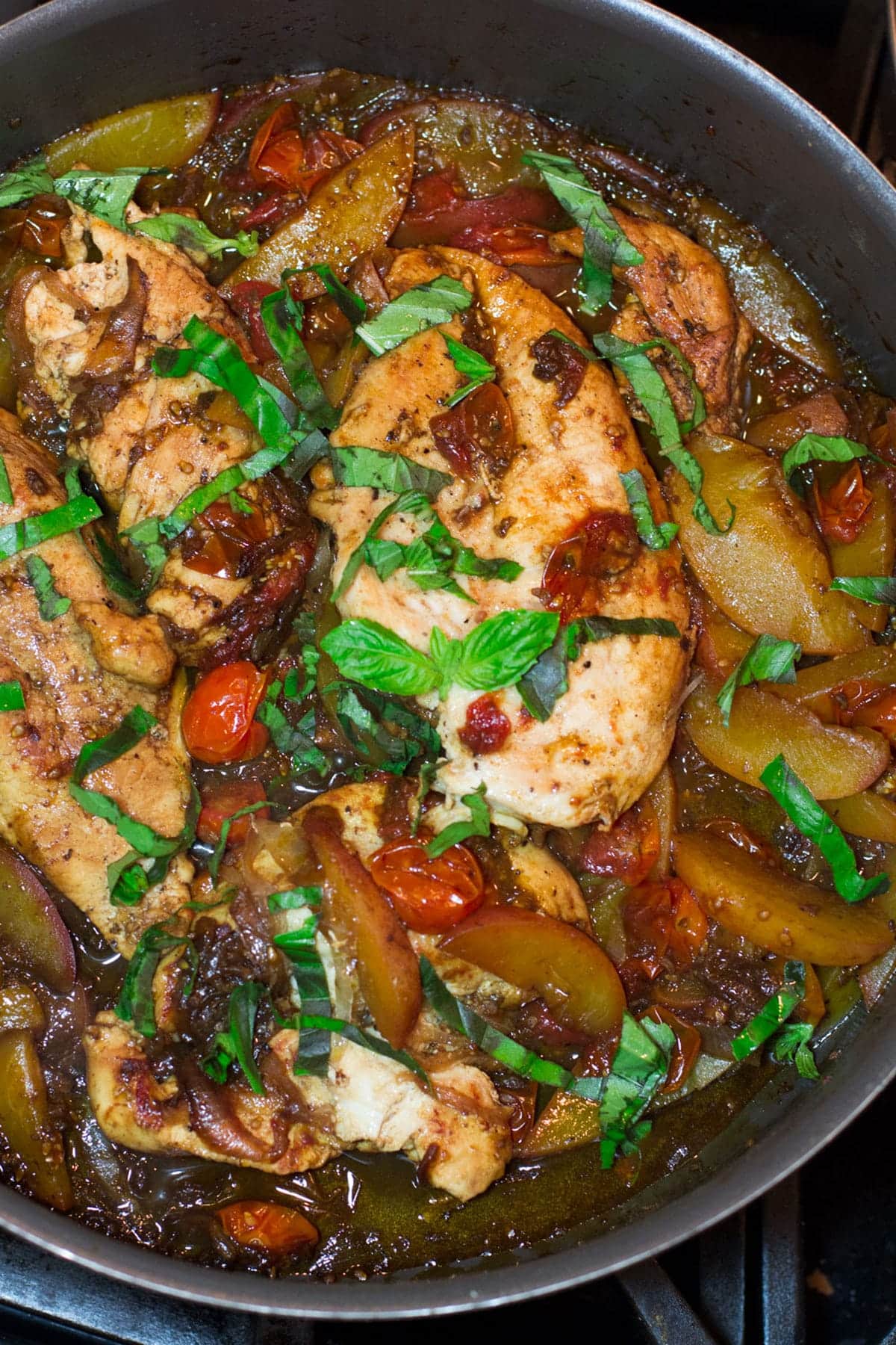 Chicken with balsamic glaze and peaches in a skillet.