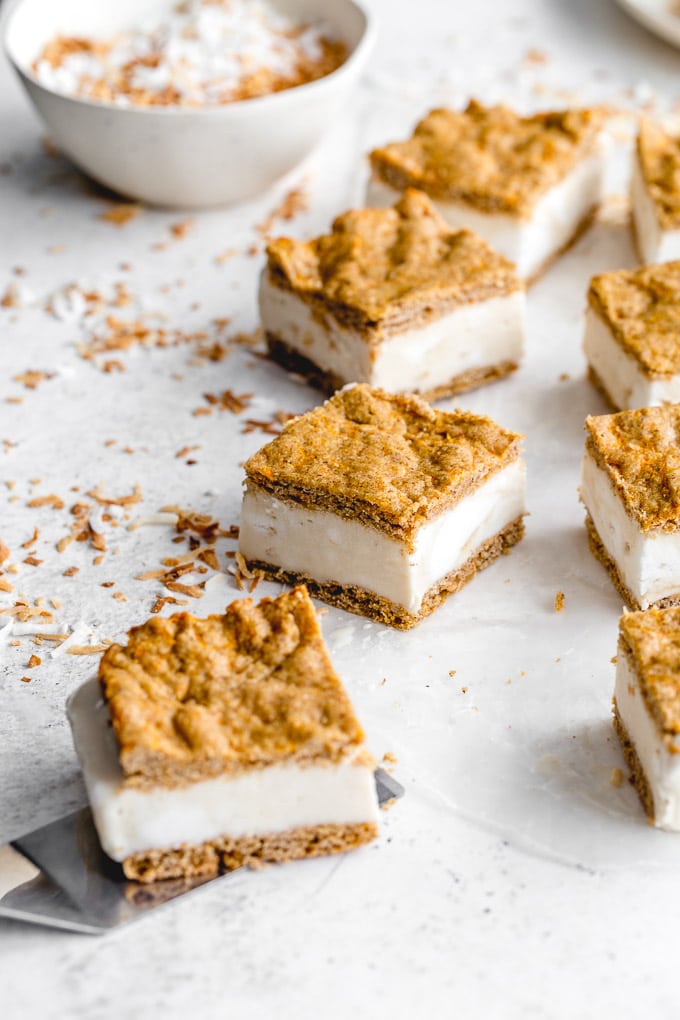 Carrot cake ice cream sandwiches on a light colored surface.