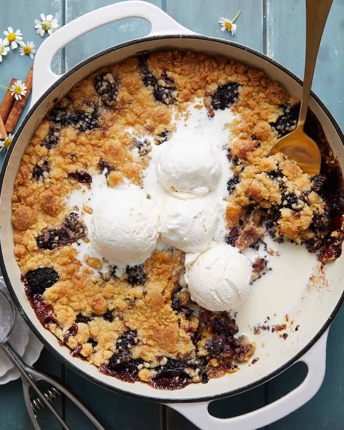 Blueberry cobbler with vanilla ice cream in a Dutch oven.
