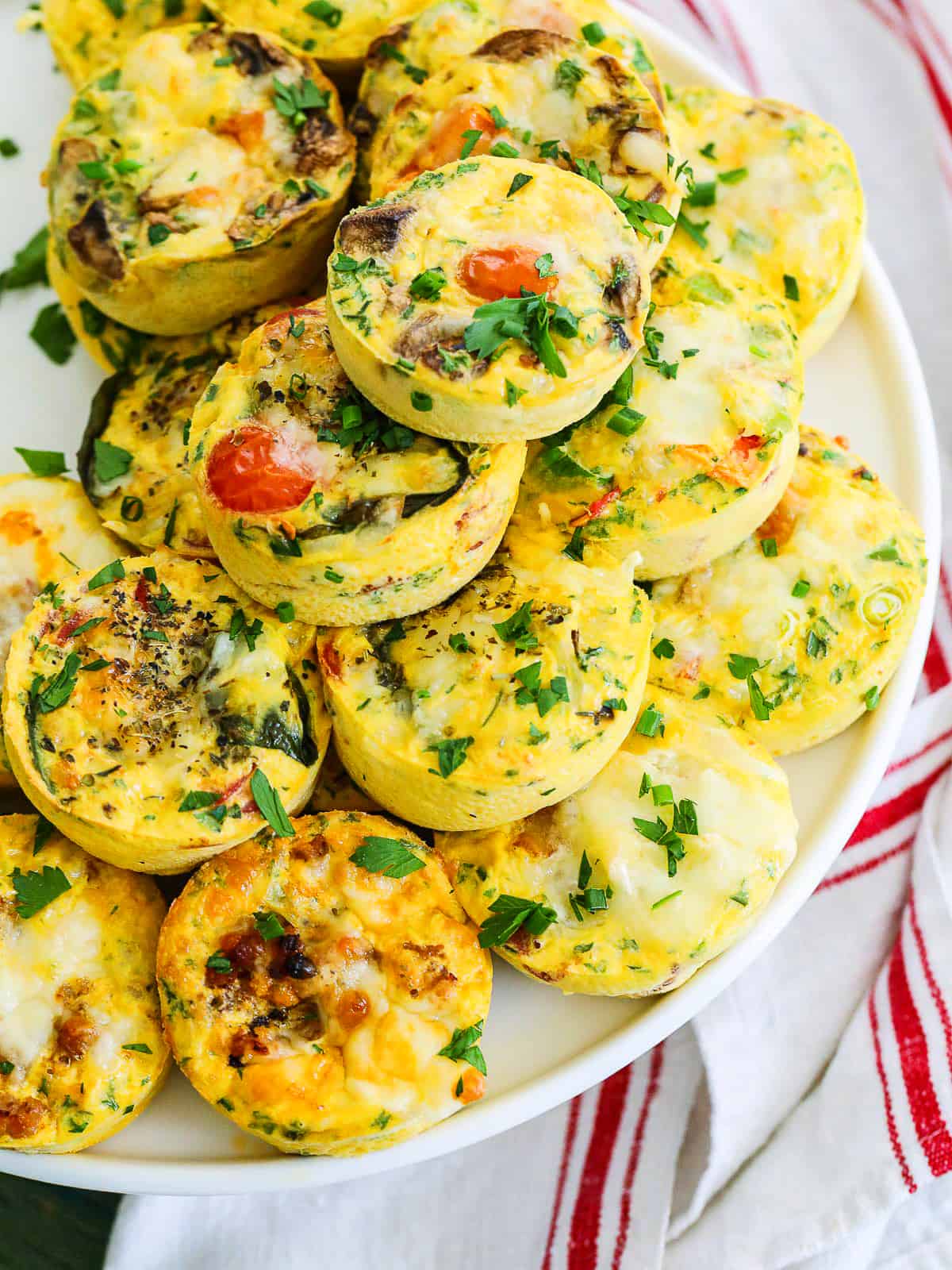 Stack of breakfast egg muffin on a white plate.