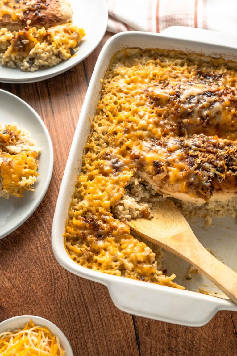 Chicken and rice casserole in a baking dish with spoon in the background.