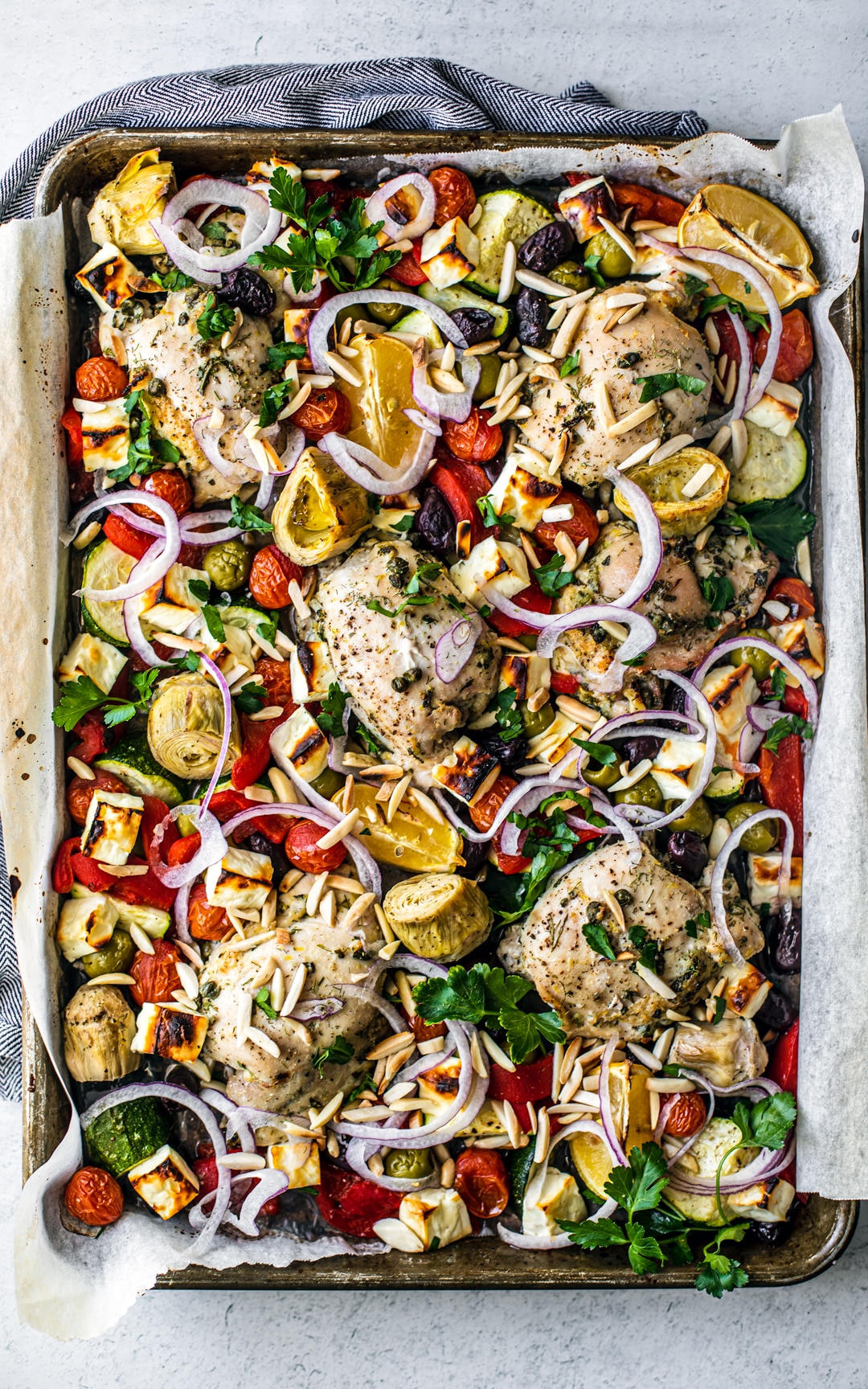 Colorful Greek sheet pan chicken with baked Feta.