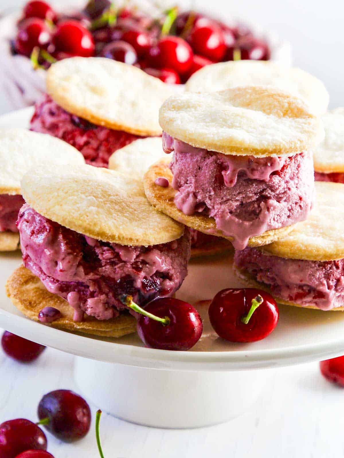 Cherry pie ice cream sandwiches on a white platter.