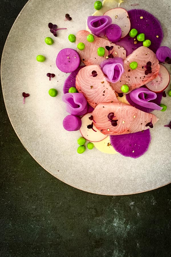 Pink fish and purple pickled radish, and peas.