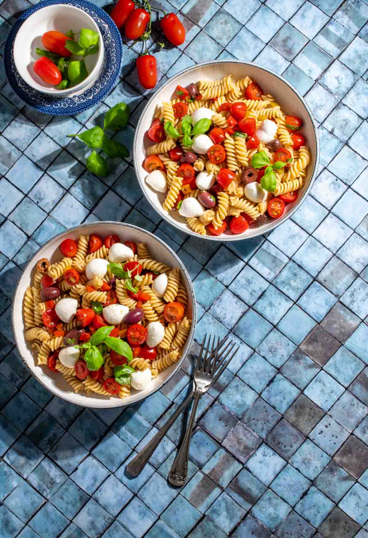 Pasta Freda in a bowl on a blue tiled background.