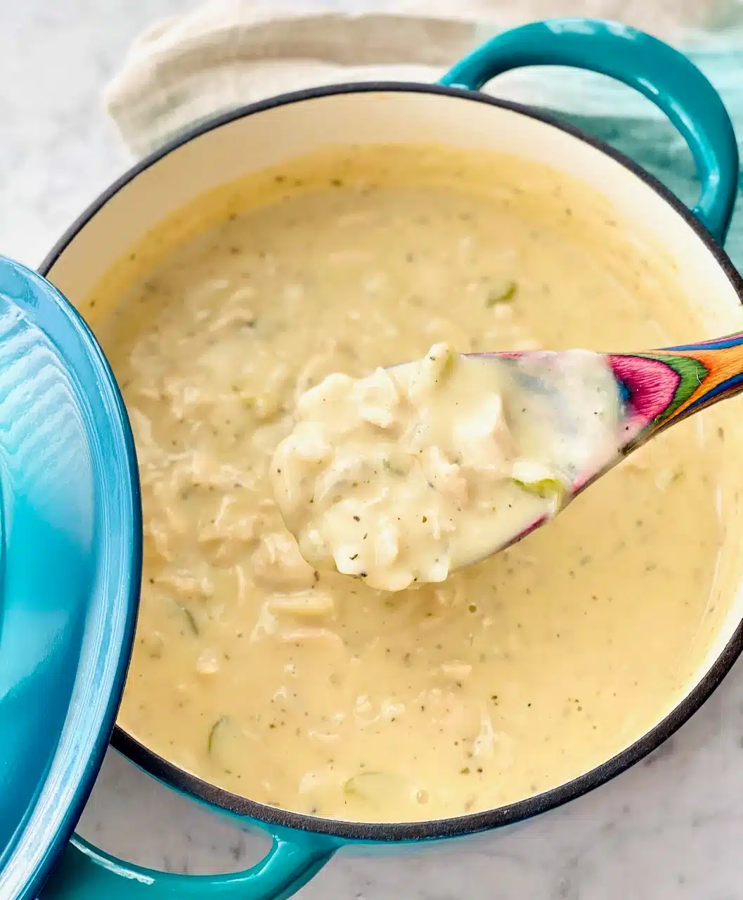 Chicken and dumplings in a blue Dutch oven.