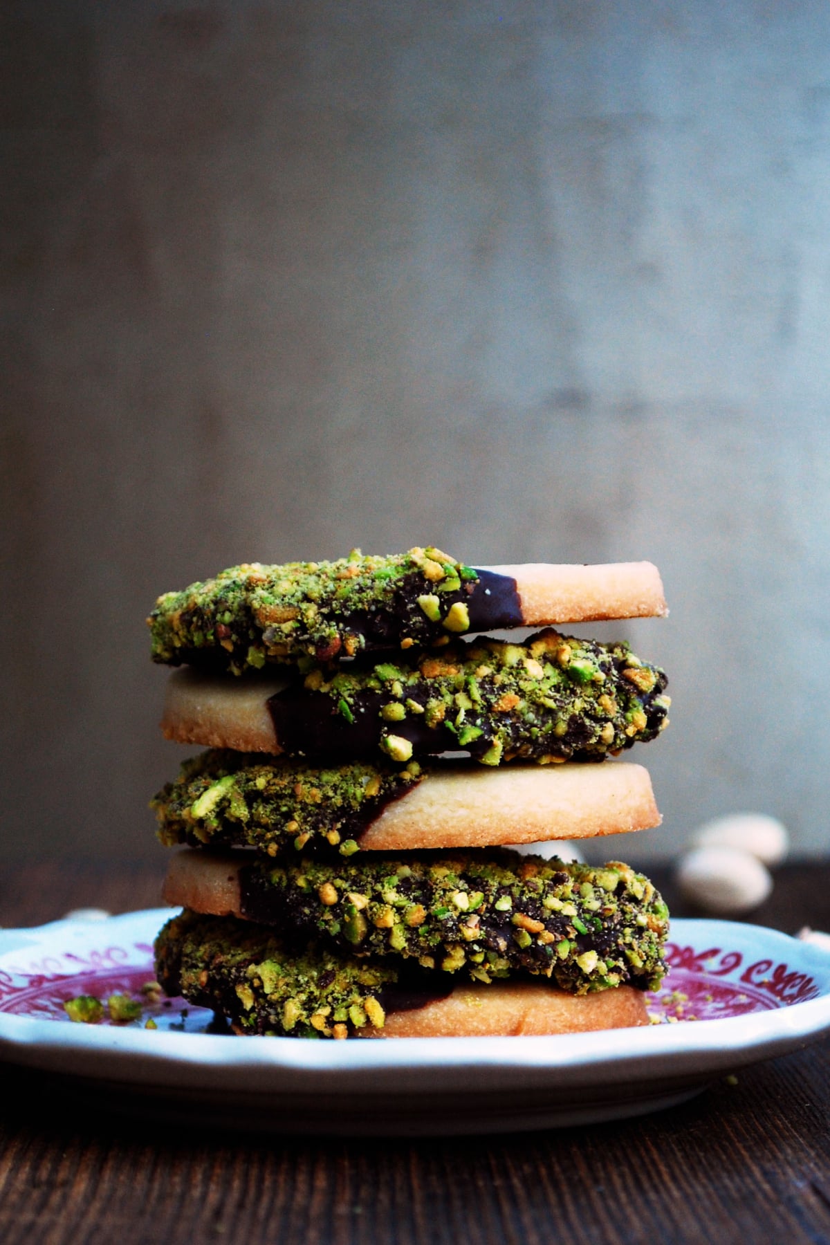 Stack of chocolate dipped pistachio shortbread cookies.