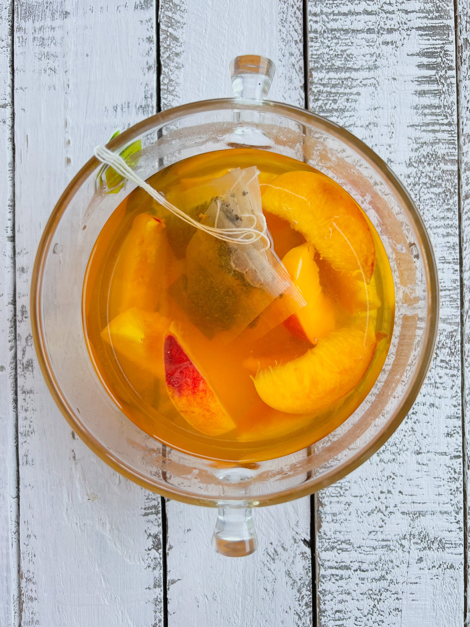 Peach tea steeping in a pitcher.