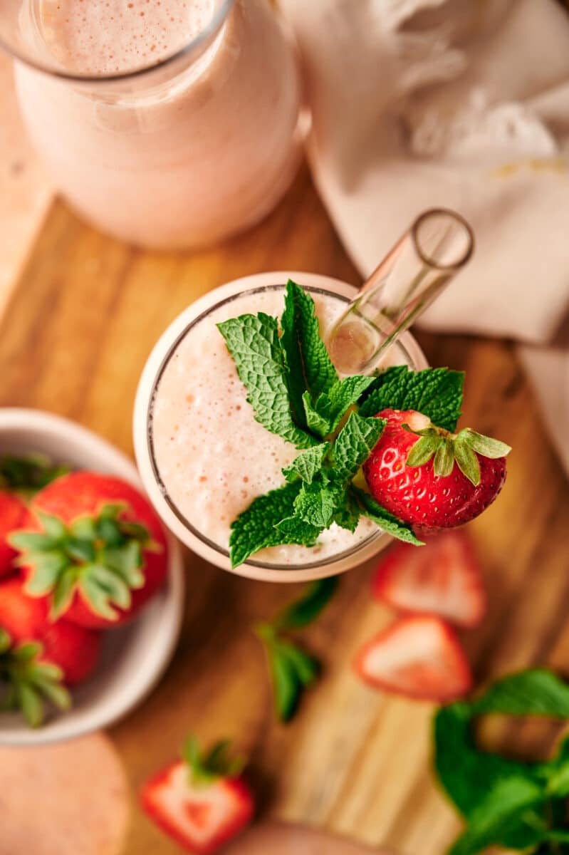 Overhead view of strawberry banana smoothie with glass straw.