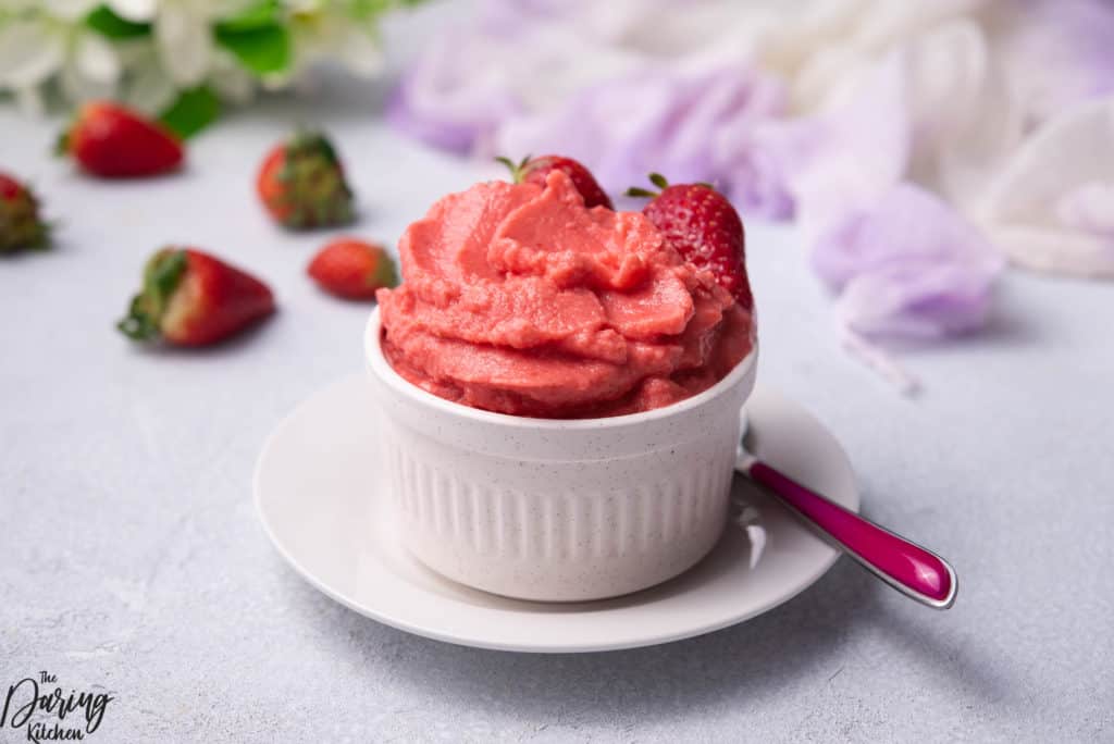 Homemade strawberry frozen yogurt in a white bowl.