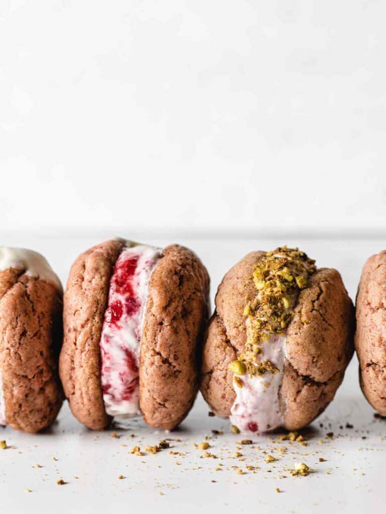 Homemade strawberry ice cream sandwiches standing upright.