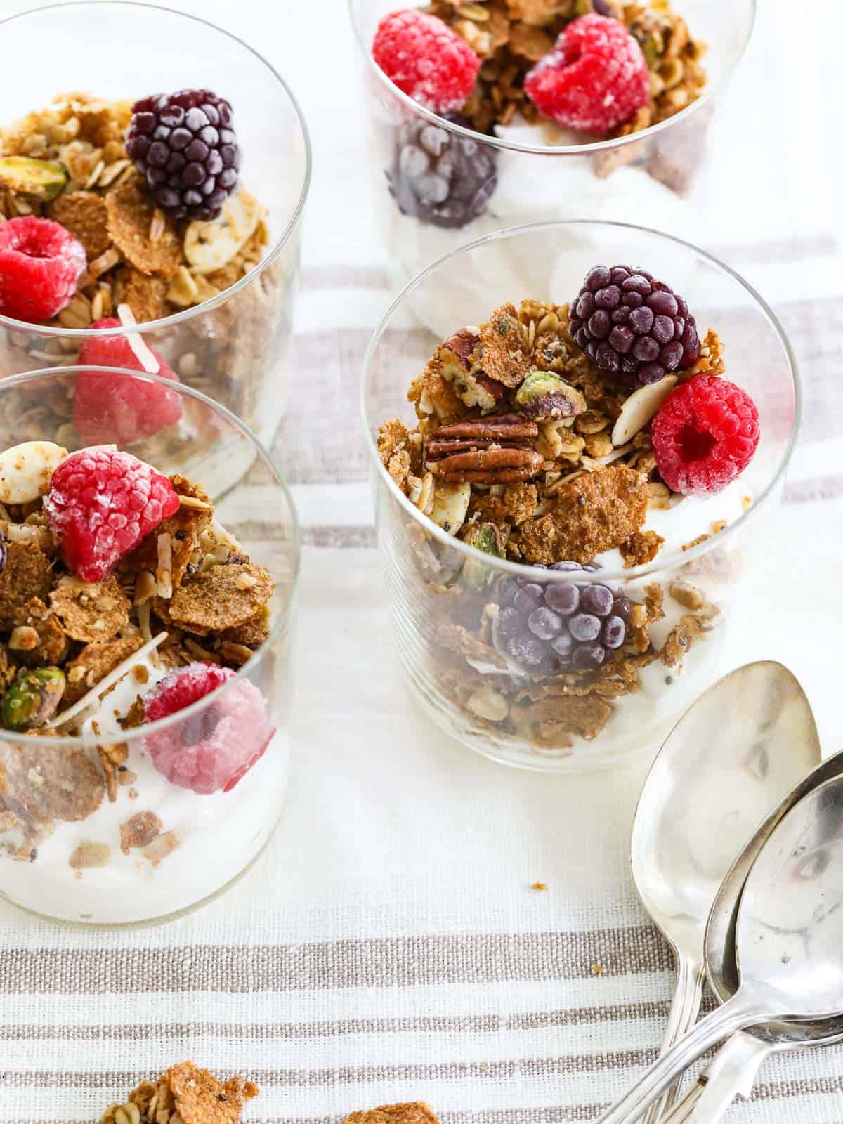 Yogurt parfait in a glass with spoons on the side.